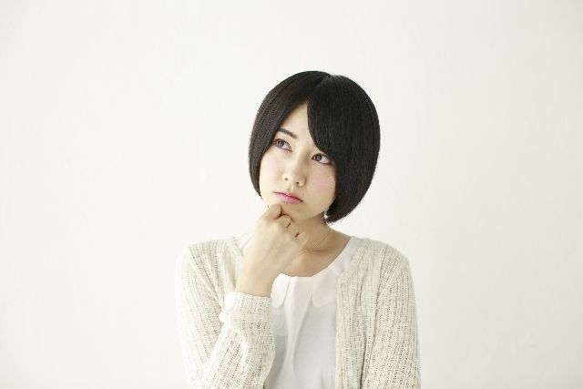 ニキビについて考える女性